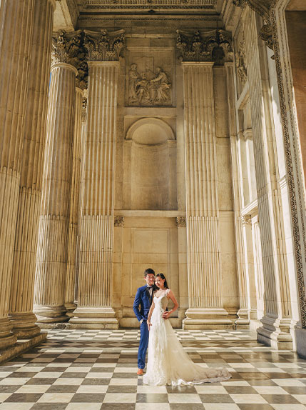 bride and groom posing in historical landmark in europe