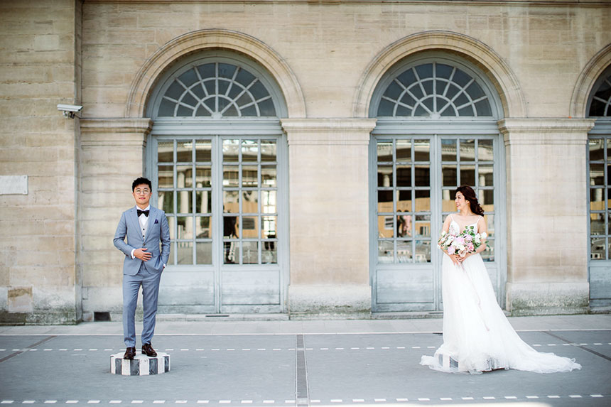 bride and groom pose near palais royal